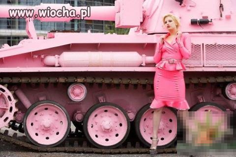 Różowa niunia lansuje się przy czołgu.