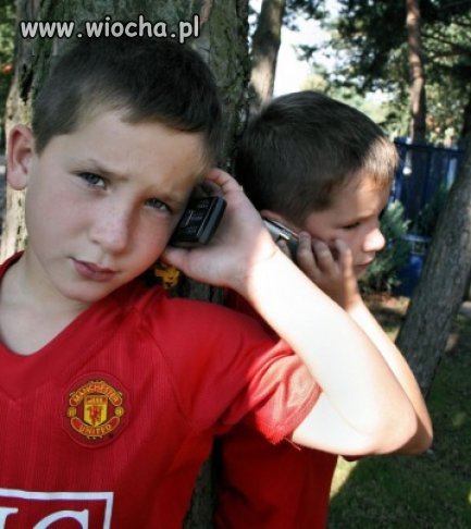 Dzieci puszczające muzykę z telefonu idąc ulicą.