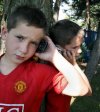 Dzieci puszczające muzykę z telefonu idąc ulicą.