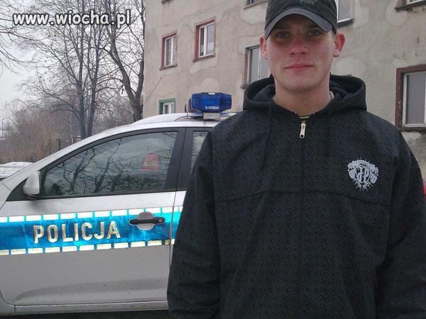 Zdjęcie w bluzie JP obok radiowozu..