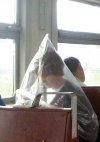 Siedzi w autobusie człowiek z workiem na głowie
