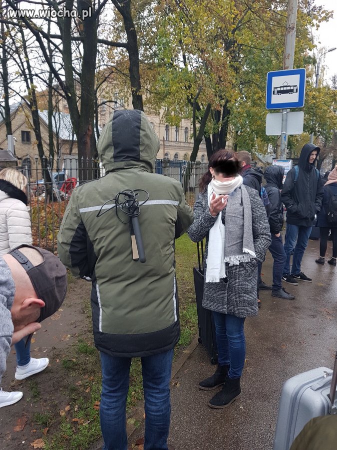 Stoi na przystanku człowiek z prostownicą na plecach